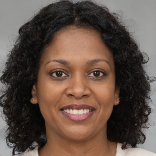 Joyful black young-adult female with medium  brown hair and brown eyes