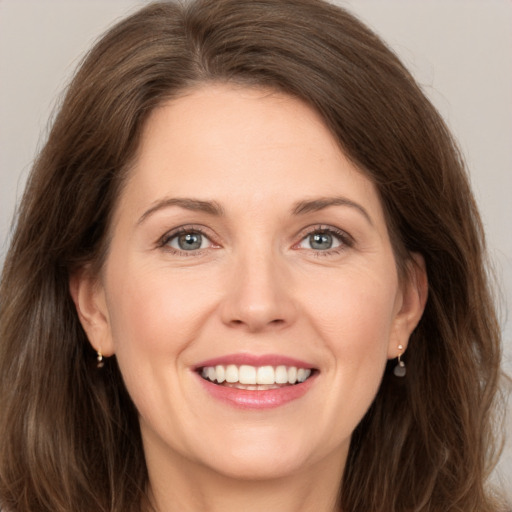 Joyful white young-adult female with long  brown hair and grey eyes