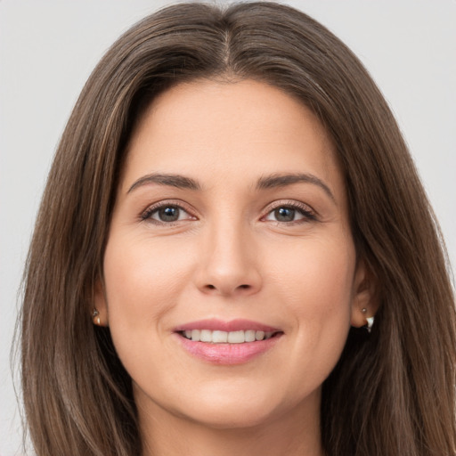 Joyful white young-adult female with long  brown hair and brown eyes