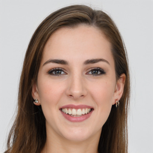 Joyful white young-adult female with long  brown hair and grey eyes