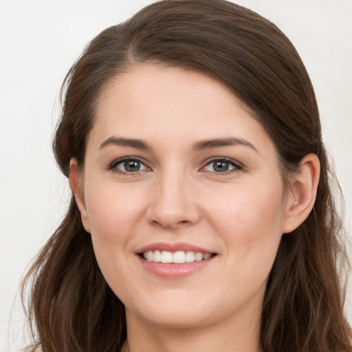 Joyful white young-adult female with long  brown hair and grey eyes