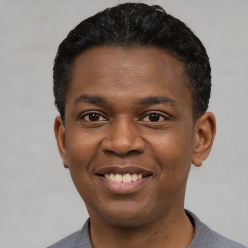 Joyful black young-adult male with short  black hair and brown eyes