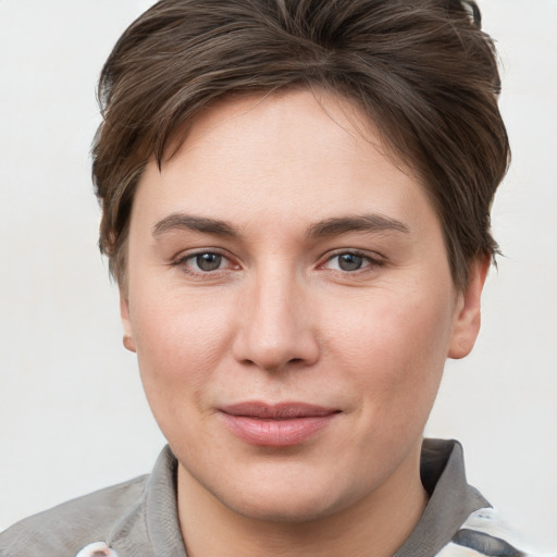 Joyful white young-adult female with short  brown hair and grey eyes