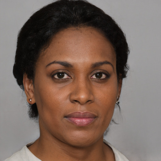 Joyful black young-adult female with short  brown hair and brown eyes