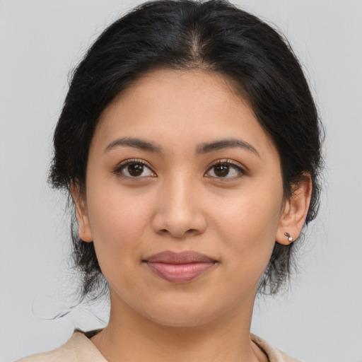 Joyful latino young-adult female with medium  brown hair and brown eyes