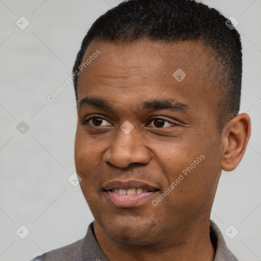 Joyful black young-adult male with short  black hair and brown eyes