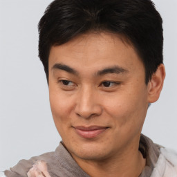 Joyful asian young-adult male with short  brown hair and brown eyes