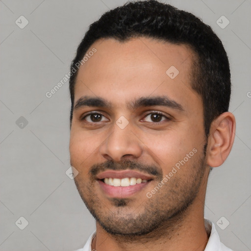 Joyful latino young-adult male with short  black hair and brown eyes