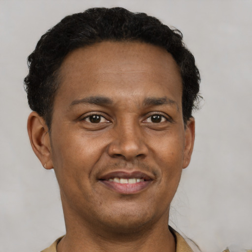 Joyful latino adult male with short  black hair and brown eyes
