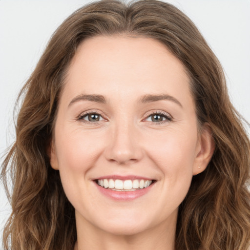 Joyful white young-adult female with long  brown hair and green eyes