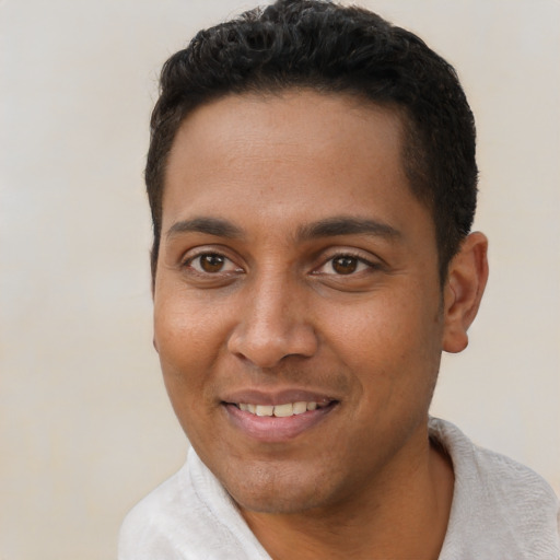 Joyful black young-adult male with short  brown hair and brown eyes