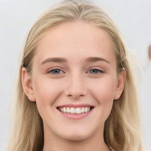 Joyful white young-adult female with long  brown hair and blue eyes