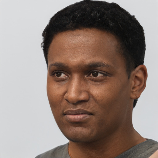 Joyful black young-adult male with short  black hair and brown eyes
