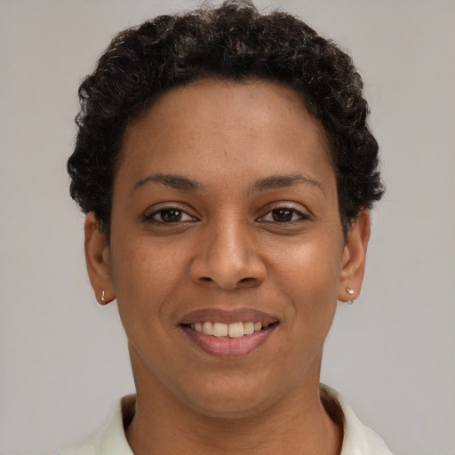 Joyful black young-adult female with short  brown hair and brown eyes