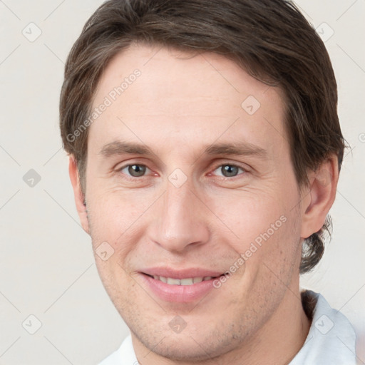 Joyful white young-adult male with short  brown hair and grey eyes