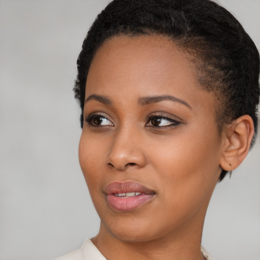 Joyful black young-adult female with short  brown hair and brown eyes