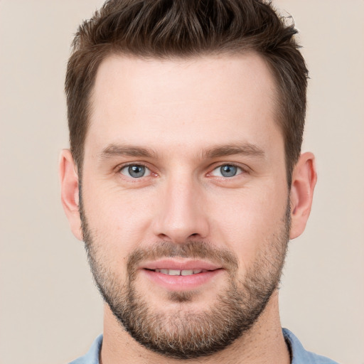 Joyful white young-adult male with short  brown hair and grey eyes