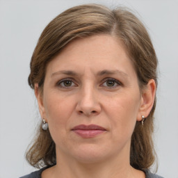 Joyful white adult female with medium  brown hair and grey eyes