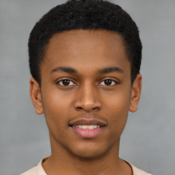 Joyful black young-adult male with short  brown hair and brown eyes