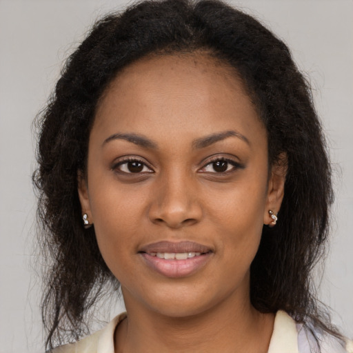 Joyful black young-adult female with long  brown hair and brown eyes
