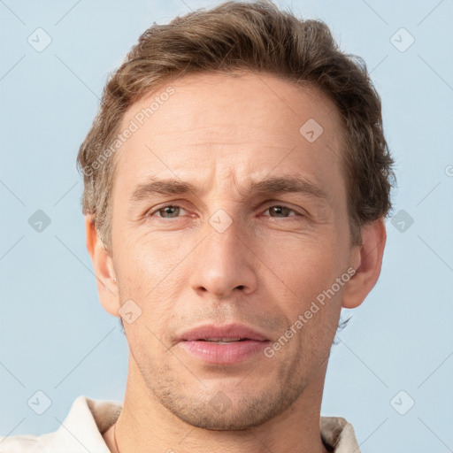 Joyful white adult male with short  brown hair and grey eyes