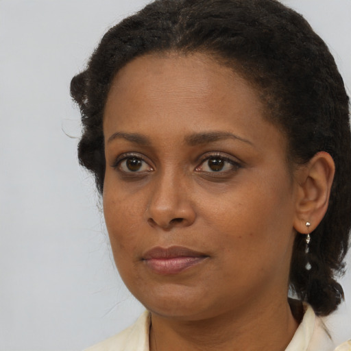 Joyful black young-adult female with medium  brown hair and brown eyes