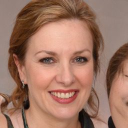 Joyful white adult female with medium  brown hair and blue eyes