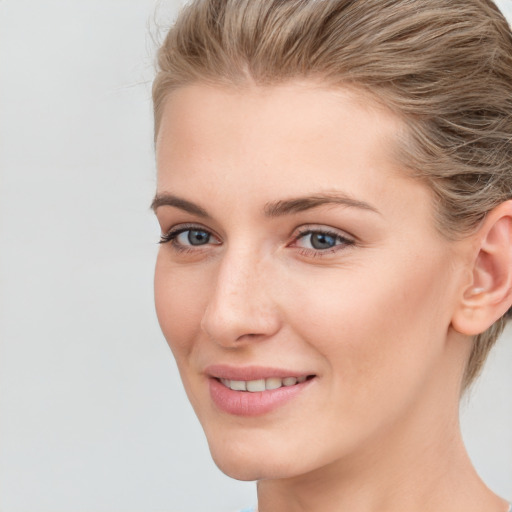 Joyful white young-adult female with medium  brown hair and blue eyes