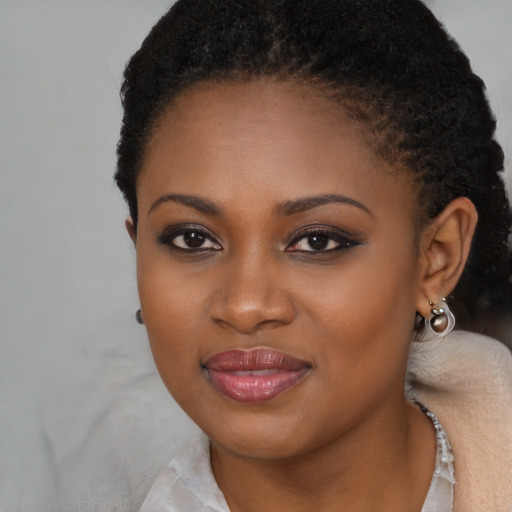 Joyful black young-adult female with long  brown hair and brown eyes