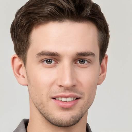 Joyful white young-adult male with short  brown hair and grey eyes