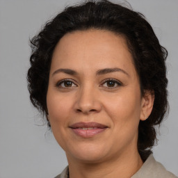 Joyful latino adult female with medium  brown hair and brown eyes