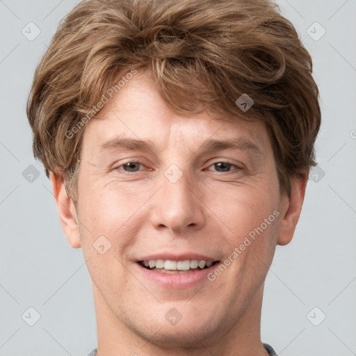 Joyful white adult male with short  brown hair and grey eyes