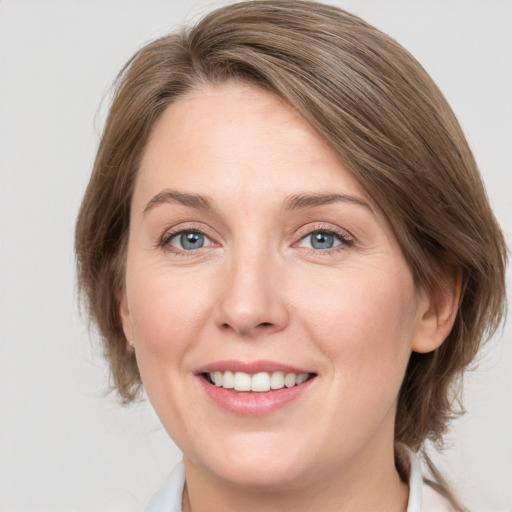 Joyful white adult female with medium  brown hair and grey eyes