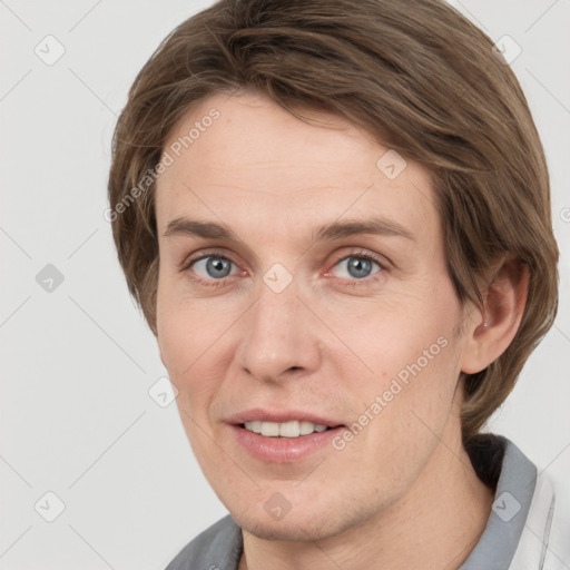 Joyful white young-adult male with medium  brown hair and grey eyes