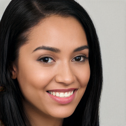 Joyful latino young-adult female with long  brown hair and brown eyes