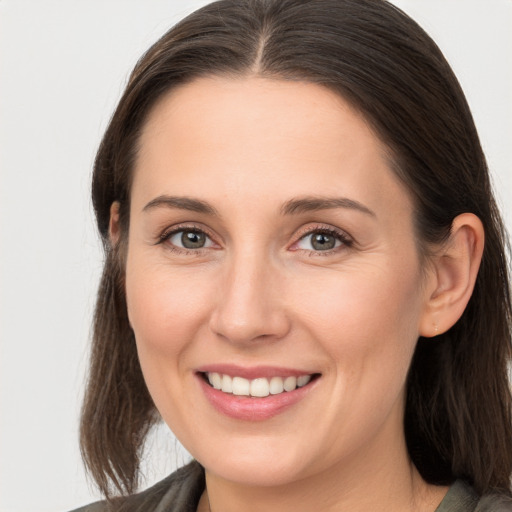 Joyful white young-adult female with medium  brown hair and grey eyes