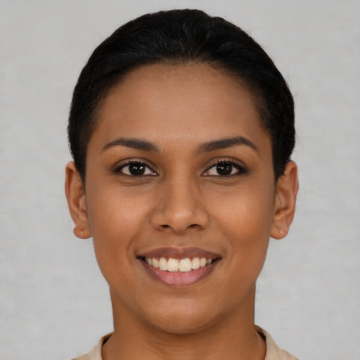 Joyful latino young-adult female with short  black hair and brown eyes