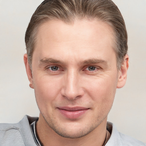 Joyful white adult male with short  brown hair and grey eyes