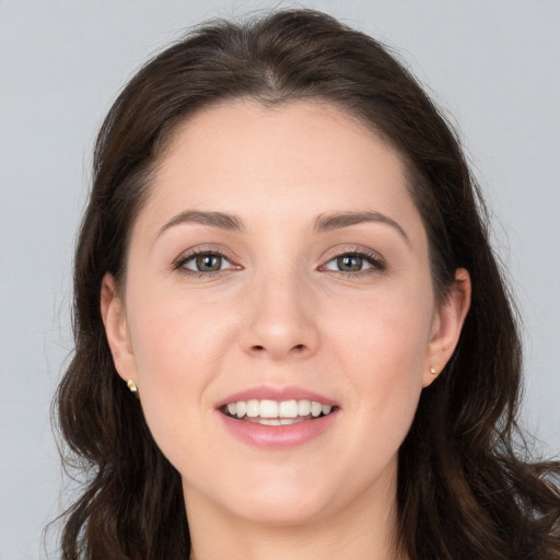 Joyful white young-adult female with long  brown hair and brown eyes