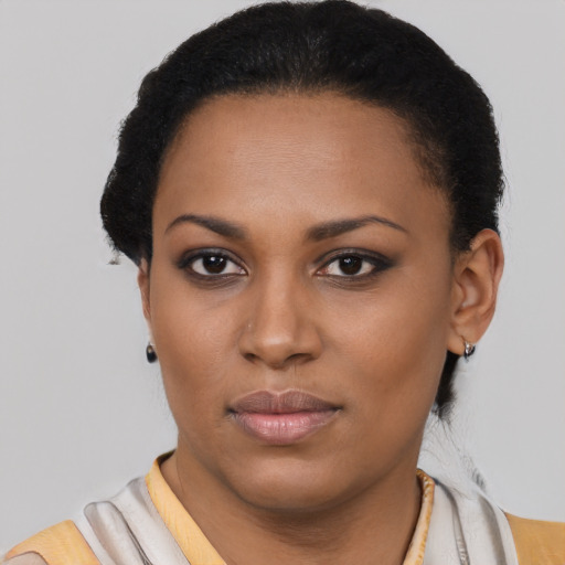 Joyful black young-adult female with short  black hair and brown eyes
