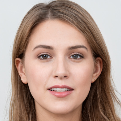 Joyful white young-adult female with long  brown hair and grey eyes