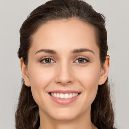 Joyful white young-adult female with long  brown hair and brown eyes