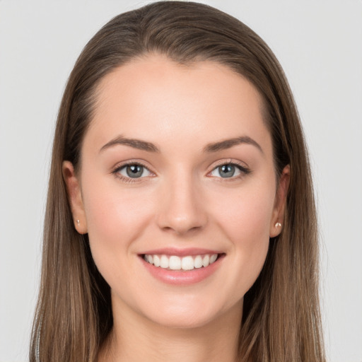 Joyful white young-adult female with long  brown hair and grey eyes