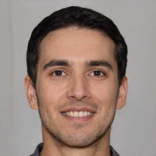 Joyful white young-adult male with short  brown hair and brown eyes