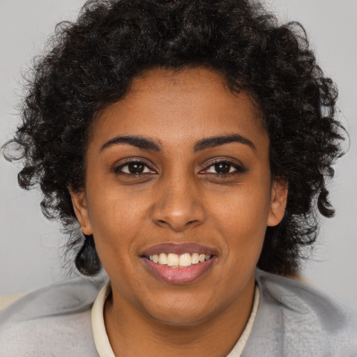 Joyful black young-adult female with short  brown hair and brown eyes