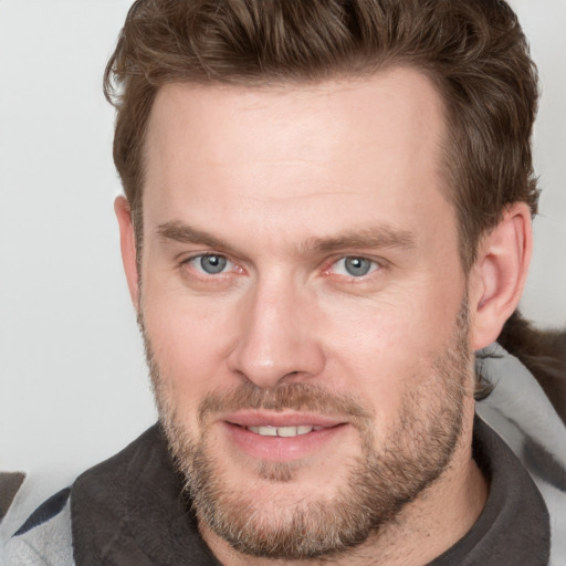 Joyful white adult male with short  brown hair and grey eyes