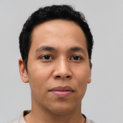 Joyful latino young-adult male with short  brown hair and brown eyes