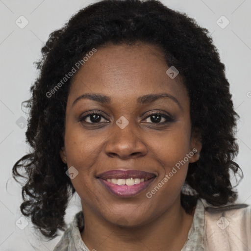 Joyful black adult female with long  brown hair and brown eyes