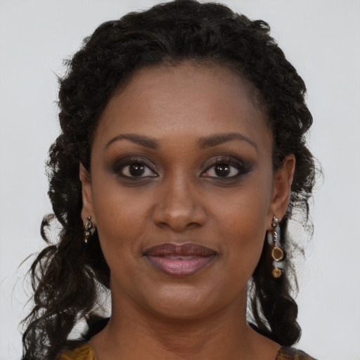 Joyful black young-adult female with long  brown hair and brown eyes