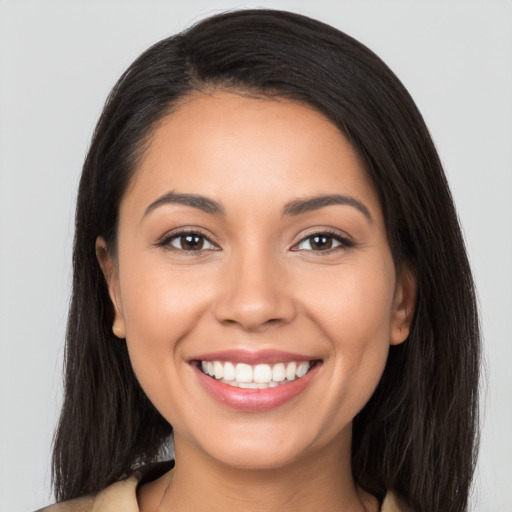 Joyful latino young-adult female with long  black hair and brown eyes